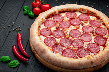 Tasty pepperoni pizza and cooking ingredients tomatoes basil