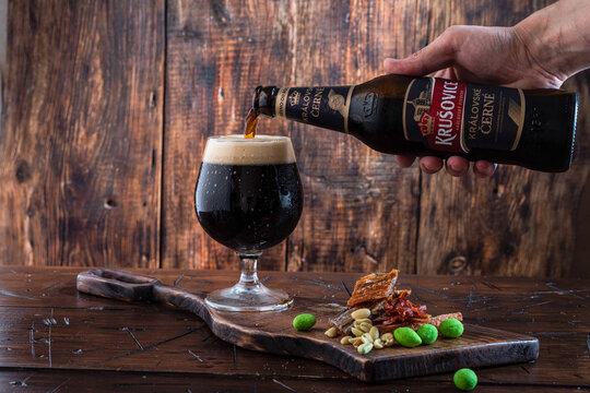Kyiv, Ukraine: Aug 21, 2022: Black beer Krusovice. Pouring beer into a glass. Cool dark beer.