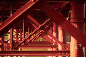 川にかかる赤い鉄橋と橋脚が生み出す幾何学模様