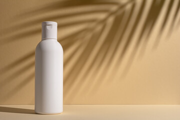 White blank packaging cosmetic bottle with shadow of palm leaves