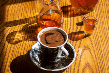 Coffee and brandy on a wooden table...alcohol drink called "rakija"..."sljivovica"...