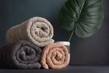 Rolled cotton towels and monstera leaf