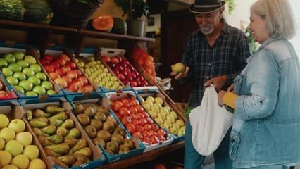 Happy senior couple buying fruits and vegetables at the market - Shopping food concept - Powered by Adobe