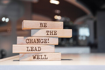 Wooden blocks with words 'Be the change, lead well'.