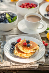 Fresh and hot american pancakes for breakfast in the garden.