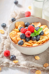 Fresh and delicious cornflakes with berries and milk for breakfast.