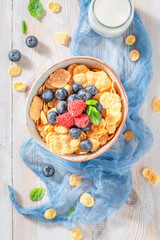 Tasty and sweet cornflakes with berries and milk for breakfast.