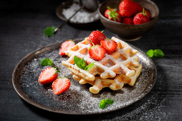 Homemade and fresh wafers with powdered sugar and berries.