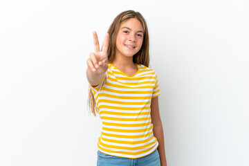 Little caucasian girl isolated on white background smiling and showing victory sign