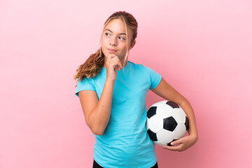 Little football player girl isolated on pink background and looking up