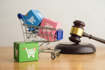 Trolley, online shopping boxes and hammer judge gavel on wooden background. Consumer rights and responsibilities to safety, customer protection in online shopping e-commerce, commercial law concept. - obrazy, fototapety, plakaty
