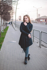 blonde girl in a jacket in the rain outside in autumn in the cold