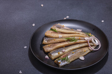 Fillet of pickled marinated sea herring fish with shallots and dill. Served ready to eat seafood