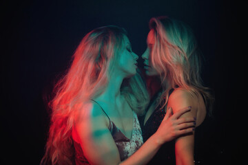 Young platinum blondes flirting under blue and red lights