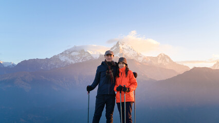 A young couple travellers trekking in Poon Hill view point in Ghorepani, Nepal.
