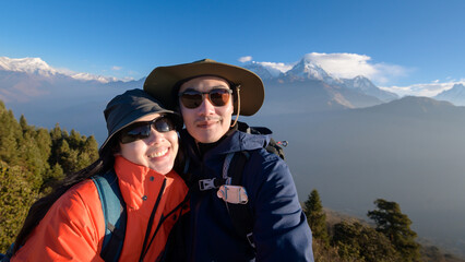 A young couple travellers trekking in Poon Hill view point in Ghorepani, Nepal.