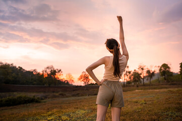 Silhouette woman over golden sunset background feeling happy successful in her life