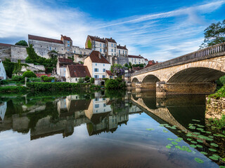 The medieval walled city of Pesmes in Burgundy. Reflection in the river at sunset.