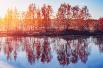 Fog above the lake at cold autumn sunrise.