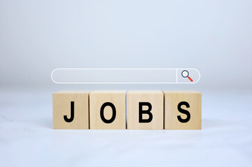 A wooden block with the word Jobs and a magnifying glass and a search bar at the top indicates a job search or company HR needs the right people to work. recruitment concept.