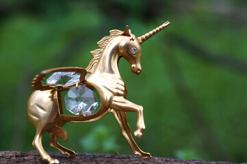 Metal unicorn figurine on a natural background. Talismans and amulets of Feng shui. A mythological...
