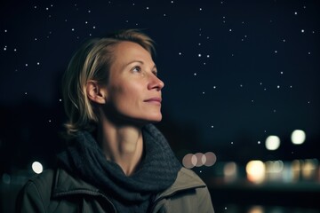 Fototapeta na wymiar Photography in the style of pensive portraiture of a pleased woman in her 40s wearing a chic cardigan against a meteor shower or night sky background. Generative AI