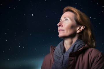 Portrait of senior woman looking away against starry night sky background