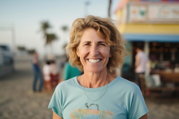 Portrait of smiling senior woman standing on beach with people in background