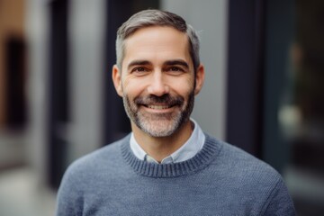 Obraz premium Portrait of a handsome middle-aged man in a gray sweater