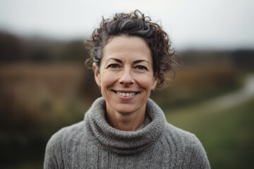 Portrait of a smiling middle-aged woman in the countryside.
