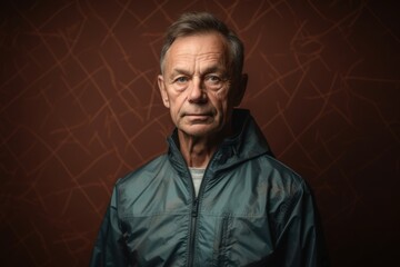 Obraz premium Portrait of a senior man in a jacket on a brown background