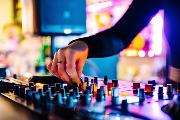 DJ Hands creating and regulating music on dj console mixer in concert nightclub stage