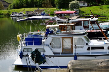 Hausboot, Boote und Yachten im Sommer im Yachthafen an der Mosel zwischen Weinbergen im Frühling...