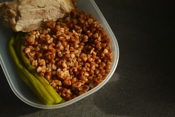 container with healthy food, buckwheat, chicken breast and asparagus