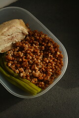 container with healthy food, buckwheat, chicken breast and asparagus