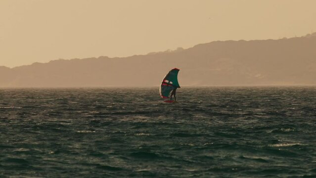 Windsurfers On Water Against Background Of Sea.