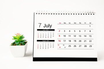 The July 2023 Monthly desk calendar for 2023 year with plant pot isolated on white background.