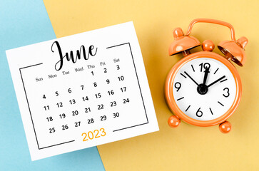 The June 2023 Monthly calendar for 2023 year with alarm clock on beautiful background.