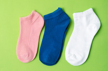 The Socks of different colors on green color background.