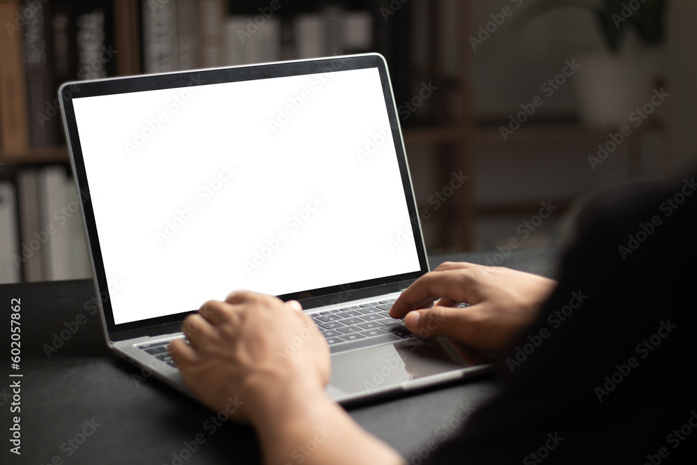 Poster mockup of man using and typing on laptop with blank white desktop screen.
