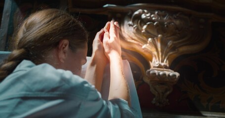 Woman raised her hands to heaven in worship to God in church. Folded hands in prayer.
