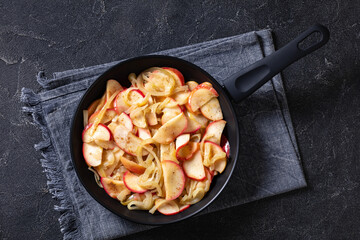 fried onion and red apple slices on skillet