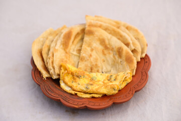 desi breakfast egg omelet and paratha served in dish isolated on background top view of bangladesi breakfast