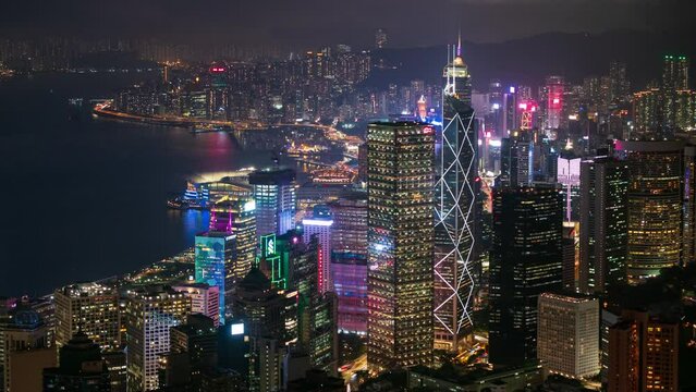 4K Time lapse Panoramic view of Hong Kong City during day to night. View of financial district high-rise and residential buildings lighting up after sunset from mountain peak Observation.
