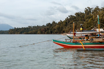Puerto Princesa, Philipines, 29 march 2022. Traditional Bangka catamaran boats in a bay in Palawan used by fishermen to go fishing. Blue see, tranquil scene.