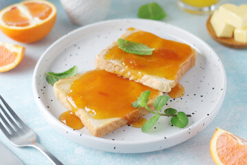 Sandwiches with marmalade, orange juice and coffee ready for breakfast