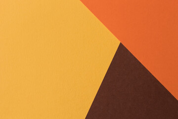 Orange and brown paper lies on the table, creating a geometric composition