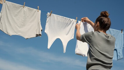 Woman hangs laundry on clothesline