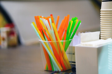 Obraz premium Multi-colored straws for drinks are on the table in a transparent glass