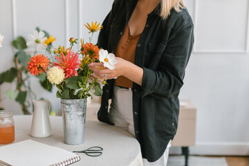 Close-up of a woman arranging flowers in a vase